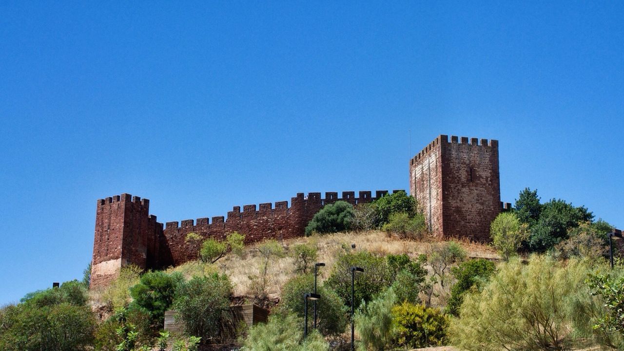 clear sky, built structure, architecture, building exterior, blue, copy space, history, low angle view, tree, religion, the past, day, place of worship, old ruin, castle, old, stone material, famous place, outdoors, travel destinations