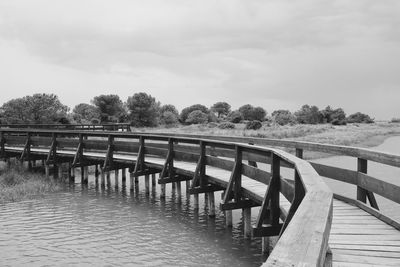Empty pier on lake against sky