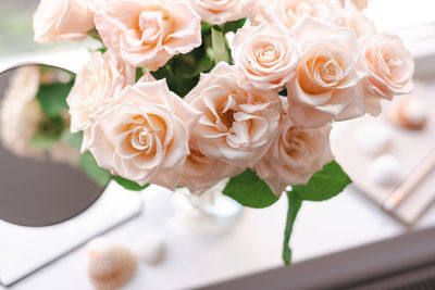 Bouquet of roses on the windowsill in the interior of the bedroom.