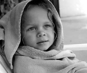 Close-up of cute boy wrapped in towel while sitting at home