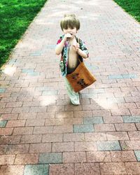 Full length of boy standing on pavement 