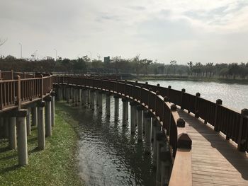 Wooden bridge over river against sky