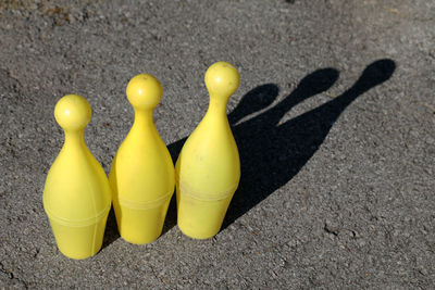 High angle view of yellow bowling pins on road