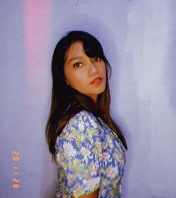 Portrait of woman standing against wall