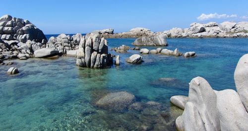 Panoramic view of rocks in sea against blue sky