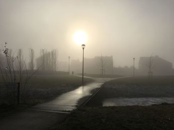 Snow covered landscape against sky during foggy weather