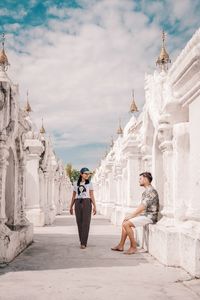 Woman standing outside temple against building