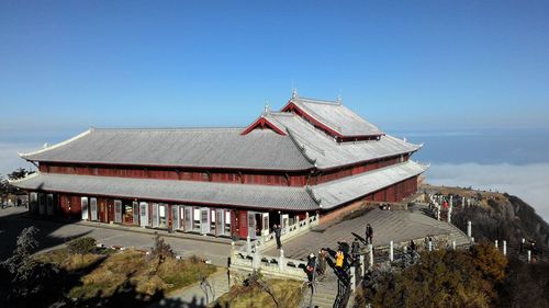 Group of people in temple building against clear blue sky