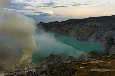 Smoke emitting from volcanic mountain against sky