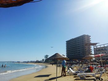 Man on beach against clear sky