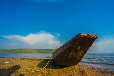 Abandoned boat on beach against sky