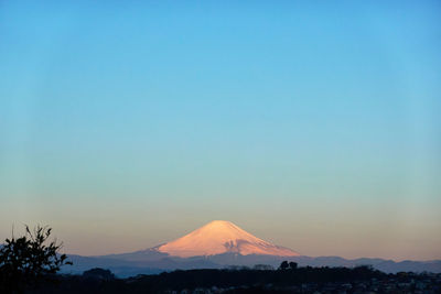 Scenic view of silhouette mountains against clear sky during sunset