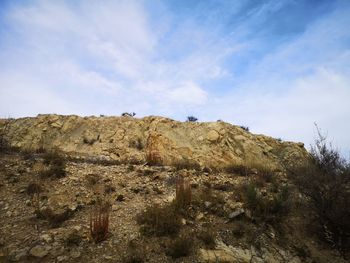 Low angle view of rocks on land against sky