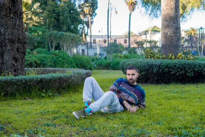 Caucasian model relaxing on the grass in a public park