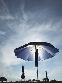 Low angle view of umbrella against blue sky