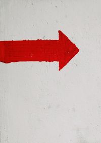 Close-up of red umbrella on white wall