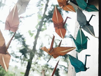 Low angle view of paper birds hanging outdoors