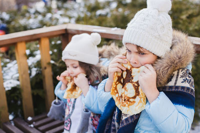 Girls eating tortilla while standing outdoors