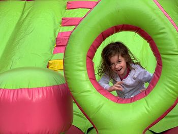 Portrait of smiling cute girl standing in bouncy castle