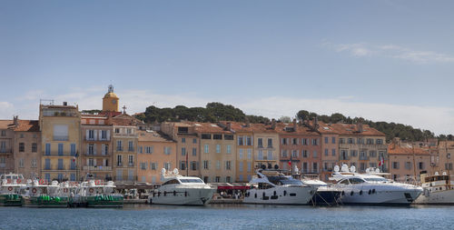 Boats moored on shore against sky