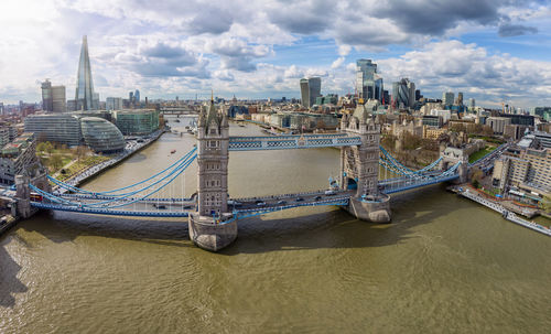 Aerial view of bridge over river in city against sky