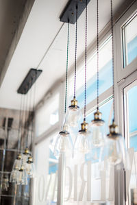 Low angle view of light bulb hanging on ceiling in building