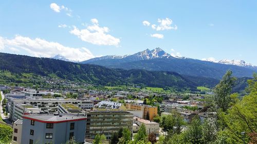 Aerial view of townscape and mountains against sky