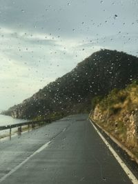 Road seen through wet glass window