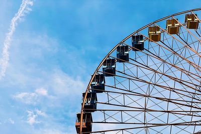 Low angle view of ferris wheel against blue sky