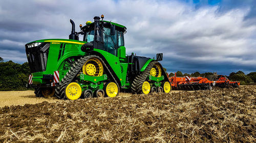 Tractor on agricultural field against sky