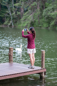 Full length of woman standing on pier over lake