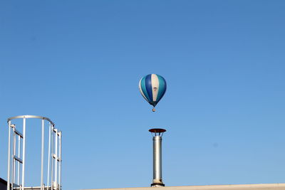 Low angle view of hot air balloon against clear blue sky