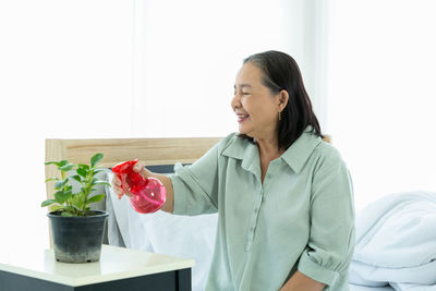 Woman standing by potted plant