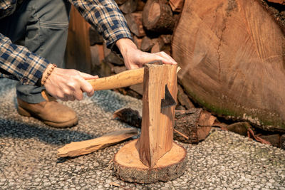 Man uses ax to break wood to use for bbq. preparation of wood to light a fire to cook food on grill