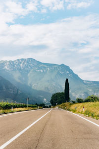 Road leading towards mountains against sky