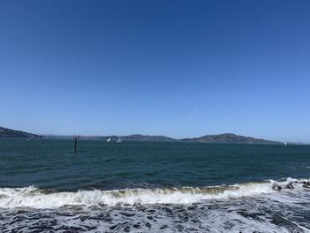 Scenic view of sea against clear blue sky