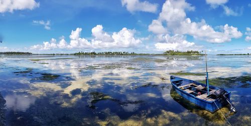 Panoramic view of boats moored in sea against sky