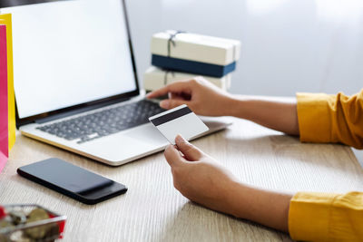 Midsection of man using laptop on table