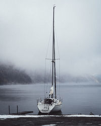 Sailboat moored on sea against sky