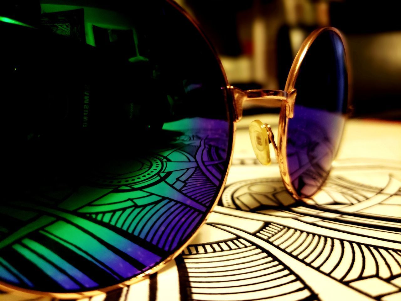 CLOSE-UP OF SUNGLASSES ON GLASS TABLE