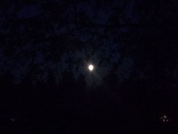 Low angle view of illuminated moon against sky at night