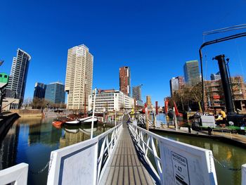 Canal amidst buildings against clear blue sky