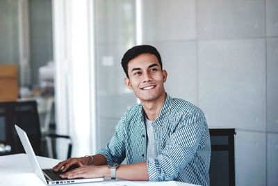 Portrait of young man sitting on table