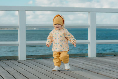 Portrait of boy standing on pier