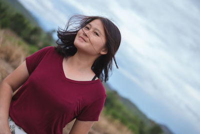 Beautiful young woman standing against blurred background