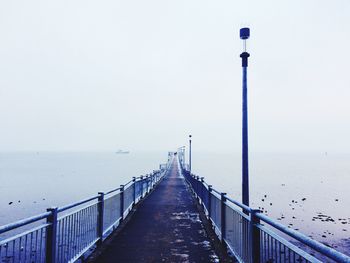 Pier amidst sea against clear sky