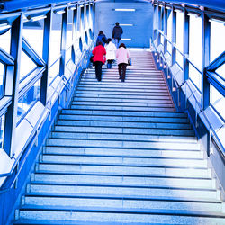 Rear view of people walking on staircase