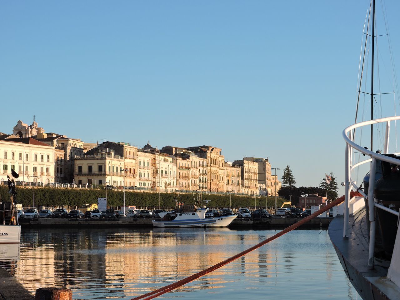 clear sky, transportation, nautical vessel, building exterior, built structure, water, architecture, moored, boat, mode of transport, canal, copy space, waterfront, city, river, residential structure, car, house, reflection, town