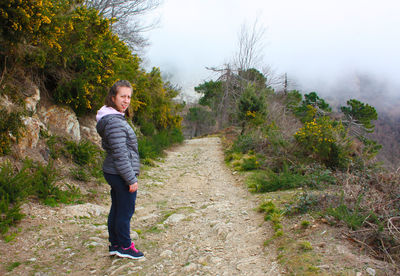 Portrait of woman standing on footpath