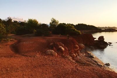 Scenic view of river against clear sky during sunset